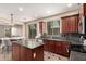 Eat-in kitchen with dark cabinets, granite countertops, stainless appliances, and a center island at 4254 S Winter Ln, Gilbert, AZ 85297
