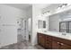 Well-lit bathroom featuring double sinks, vanity with drawers, and walk-in closet access at 5429 W Chuck Box Rd, Laveen, AZ 85339