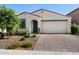 Charming single-story home with a paver driveway, desert landscaping, and a two car garage at 5429 W Chuck Box Rd, Laveen, AZ 85339