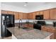 Kitchen features granite countertops, a kitchen island with a sink, and black appliances at 5429 W Chuck Box Rd, Laveen, AZ 85339