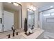Bathroom with double sinks, marble countertops, black fixtures, and a shower with an adjacent window and built-in niche at 5525 E Waltann Ln, Scottsdale, AZ 85254