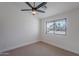 Bright bedroom with a ceiling fan and a view of a neighborhood through a window bringing in natural light at 5525 E Waltann Ln, Scottsdale, AZ 85254