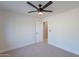 Simple bedroom featuring a ceiling fan and an open doorway that leads to another area of the house at 5525 E Waltann Ln, Scottsdale, AZ 85254