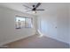 Bright bedroom with a ceiling fan, window overlooking a view, and closet for storage at 5525 E Waltann Ln, Scottsdale, AZ 85254