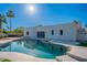 Backyard view of modern home with pristine pool, jacuzzi, and palm trees at 5525 E Waltann Ln, Scottsdale, AZ 85254