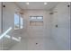 Modern shower with dual rainfall shower heads, a built-in niche, and a neutral tile design and glass enclosure at 5525 E Waltann Ln, Scottsdale, AZ 85254