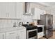 Gourmet kitchen featuring stainless steel appliances, modern backsplash, and white cabinets at 5833 N 10Th St, Phoenix, AZ 85014