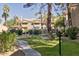 Well-maintained community green space with a sidewalk, landscaping, trees, and lush grass at 6885 E Cochise Rd # 129, Paradise Valley, AZ 85253