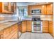 Kitchen features wood cabinets, granite counters, tile backsplash, and modern stainless steel appliances at 6885 E Cochise Rd # 129, Paradise Valley, AZ 85253