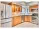 Well-equipped kitchen with stainless steel appliances, granite counters, and wood cabinetry at 6885 E Cochise Rd # 129, Paradise Valley, AZ 85253