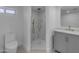 Modern bathroom features a walk-in shower with marble tile and a gray vanity with gold hardware at 701 W Windsor Ave, Phoenix, AZ 85007