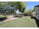 Backyard featuring low-maintenance artificial turf, mature trees, and block fencing at 7126 W Ocotillo Rd, Glendale, AZ 85303