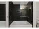 Luxurious bathroom featuring a deep soaking tub, with elegant black tiled walls and a glass enclosure at 7137 E Rancho Vista Dr # 3007, Scottsdale, AZ 85251