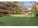 Well-manicured putting green surrounded by lush greenery and condominium buildings at 7137 E Rancho Vista Dr # 3007, Scottsdale, AZ 85251