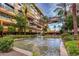Exterior of condo buildings overlooking a stone water feature surrounded by lush green plants and palm trees at 7137 E Rancho Vista Dr # 3007, Scottsdale, AZ 85251