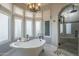 Bathroom with freestanding tub, tile floors, chandelier, and updated shower at 7471 E Northern Ave, Scottsdale, AZ 85258