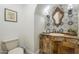 Charming powder room with antique vanity, decorative mirror and blue-patterned tile at 7471 E Northern Ave, Scottsdale, AZ 85258