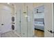 Stylish bathroom features a glass enclosed shower with gold fixtures, modern tile, and stackable W/D at 7471 E Northern Ave, Scottsdale, AZ 85258