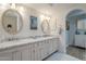 Bathroom showcasing a double vanity with marble countertop and framed mirrors at 7471 E Northern Ave, Scottsdale, AZ 85258