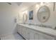Bathroom featuring a double vanity with marble countertop and framed mirrors at 7471 E Northern Ave, Scottsdale, AZ 85258