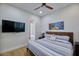 This bedroom has a mounted TV, ceiling fan, and ensuite bathroom access at 7471 E Northern Ave, Scottsdale, AZ 85258