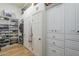 Large closet with built-in shelves and cabinets for shoe storage and organization with wooden floor at 7471 E Northern Ave, Scottsdale, AZ 85258