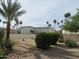 Attractive yard featuring a rock-lined desert landscape with a palm tree and lush green bushes at 7471 E Northern Ave, Scottsdale, AZ 85258