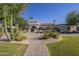 Charming white home featuring desert landscaping, terracotta roof, and a brick walkway at 7471 E Northern Ave, Scottsdale, AZ 85258
