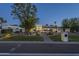 Elegant exterior elevation with a brick walkway, manicured lawn, and desert landscaping at dusk at 7471 E Northern Ave, Scottsdale, AZ 85258