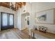 Welcoming foyer with hardwood floors, a decorative chandelier, and an arched doorway at 7471 E Northern Ave, Scottsdale, AZ 85258