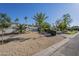 Well-maintained front yard featuring desert landscaping with various trees and shrubs and a sidewalk at 7471 E Northern Ave, Scottsdale, AZ 85258