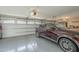 Clean garage featuring epoxy flooring, white cabinets, and a modern burgundy SUV at 7471 E Northern Ave, Scottsdale, AZ 85258