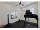 Home gym features a treadmill, ceiling fan, rubber flooring, and fitness equipment at 7471 E Northern Ave, Scottsdale, AZ 85258