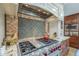 A beautifully appointed kitchen featuring a professional grade cooktop and custom tile backsplash at 7471 E Northern Ave, Scottsdale, AZ 85258