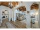 Spacious living room with hardwood floors, exposed wood beams, and views into other living areas at 7471 E Northern Ave, Scottsdale, AZ 85258