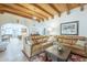 Inviting living room with wood beamed ceiling, leather sectional, and open layout at 7471 E Northern Ave, Scottsdale, AZ 85258