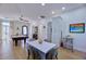 Living room offers a pool table, neutral walls, hardwood floors, dining, and outdoor access at 7471 E Northern Ave, Scottsdale, AZ 85258