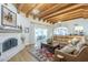 Spacious living room with a fireplace, wood beam ceiling, and sliding door to the patio at 7471 E Northern Ave, Scottsdale, AZ 85258