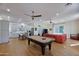Open-concept living room with a pool table, hardwood floors, and stylish decor and large windows at 7471 E Northern Ave, Scottsdale, AZ 85258