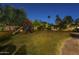 Backyard play structure with slide and swing set on a well-lit grassy lawn at 7471 E Northern Ave, Scottsdale, AZ 85258
