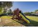 Playground in backyard with mature trees and green lawn at 7471 E Northern Ave, Scottsdale, AZ 85258