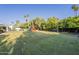 Large, private backyard with playset, lush lawn, and mature trees at 7471 E Northern Ave, Scottsdale, AZ 85258