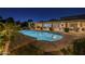 Large lighted pool with adjacent lounge seating and covered dining area at dusk at 7471 E Northern Ave, Scottsdale, AZ 85258