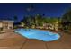 Inviting pool with cool blue water and stone accents, surrounded by mature landscaping at night at 7471 E Northern Ave, Scottsdale, AZ 85258
