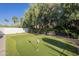 A putting green sits in a landscaped backyard, complete with flags for a fun golf experience at 7471 E Northern Ave, Scottsdale, AZ 85258
