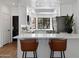 Modern kitchen with white cabinets, stainless steel appliances, quartz countertops and bar stool seating at 7760 E Pepper Tree Ln, Scottsdale, AZ 85250