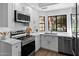 Updated kitchen with stainless steel appliances, white cabinetry, quartz countertops and hardwood floors at 7760 E Pepper Tree Ln, Scottsdale, AZ 85250