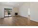 A cozy living room featuring wood floors, a modern fireplace, and sliding glass doors to the backyard at 7760 E Pepper Tree Ln, Scottsdale, AZ 85250