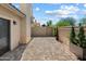 Private brick-paved patio area with stucco walls and manicured potted trees, offering a serene outdoor space at 7760 E Pepper Tree Ln, Scottsdale, AZ 85250