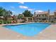 Inviting community pool surrounded by lounge chairs, manicured landscaping, and well-maintained buildings at 7760 E Pepper Tree Ln, Scottsdale, AZ 85250